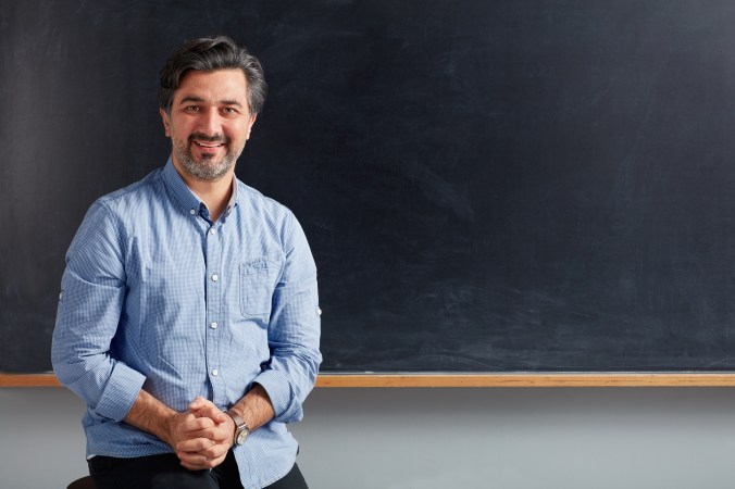 Teacher posing on blackboard.